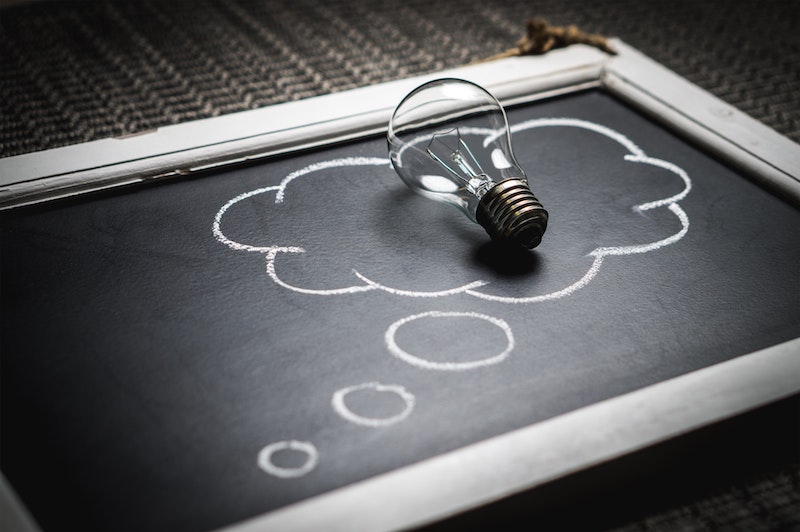 A light bulb in the middle of a thought bubble drawn on a blackboard 