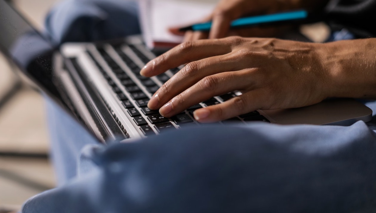 Hand typing on laptop